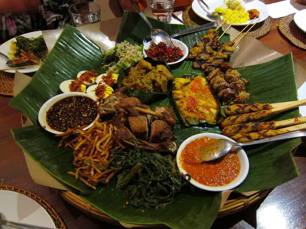 Spread of Balinese dishes on banana leaves